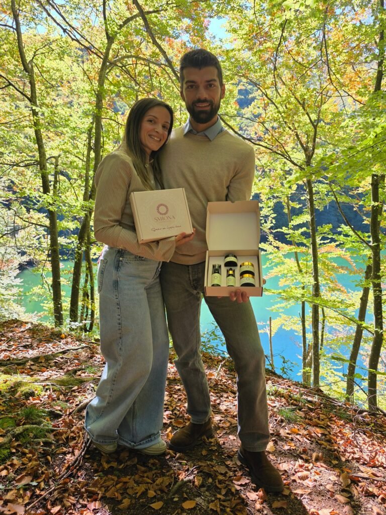 Sanja i Ognjen Srdić u šumi na Balkani drže dvije poklon kutije Smione, a u otvorenoj se vidi set prirodne kozmetike za lice